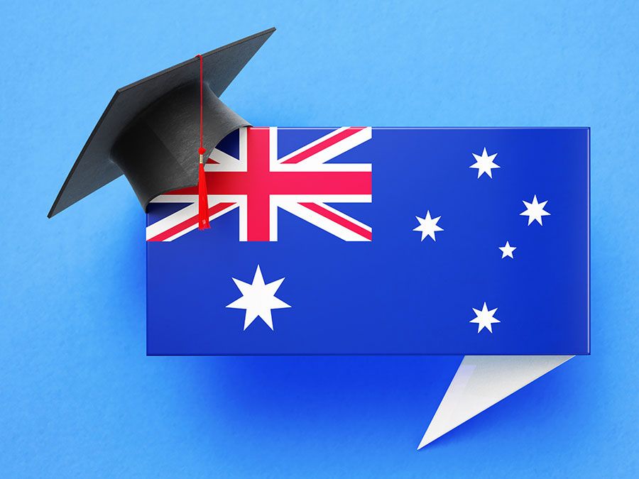 Graduation cap sitting over a speech bubble with an Australian flag on a blue background. (education)