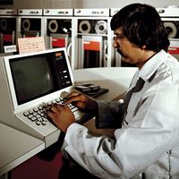 Technician operates the system console on the new UNIVAC 1100/83 computer at the Fleet Analysis Center, Corona Annex, Naval Weapons Station, Seal Beach, CA. June 1, 1981. Univac magnetic tape drivers or readers in background. Universal Automatic Computer