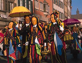 costumes with wooden masks worn during pre-Lenten celebrations