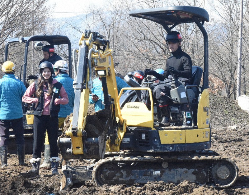 真剣な表情で重機を操作する中田英寿さん（右）＝長野県小布施町の防災パークnuovo小布施で2024年3月11日、鈴木英世撮影