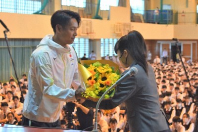 川口璃子さんから花束を受け取る荻原大地選手（左）＝鹿児島市谷山中央8の鹿児島南高校で2024年5月8日午前8時49分、梅山崇撮影