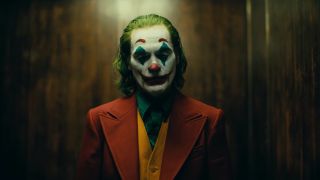 Joaquin Phoenix in full clown makeup standing in elevator during Joker