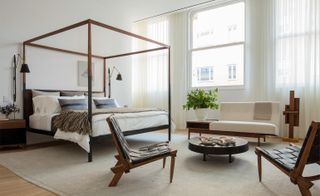 white bedroom with bed and chairs