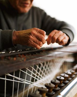 Image of man on traditional Japanese weaving machine