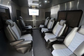 interior photo looking toward the back of a large gray van, showing six bucket seats