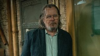 Gary Oldman leans against a door frame in Slow Horses season 4