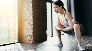 a woman leaning into a low squat