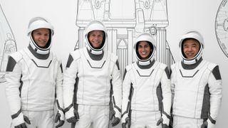 four astronauts dressed in spacex&#039;s black-and-white spacesuits pose at the company&#039;s california headquarters during a training session