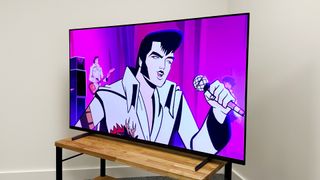 Sony A80L on a TV cabinet in the corner of a room. On screen is a hand-drawn animated show with a close-up of Elvis singing into a microphone, with a guitarist in the background in front of a purple backdrop.