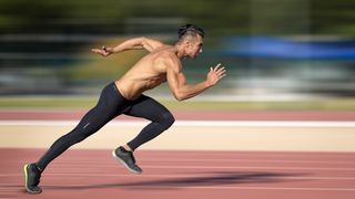 a photo of a male runner sprinting on a track