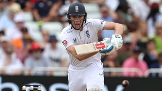 Zak Crawley of England plays a shot in his Test whites and blue England helmet.