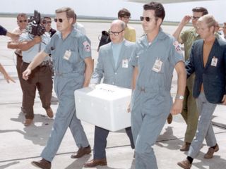 Apollo 11 moon rocks being carried into NASA's Lunar Receiving Laboratory after their arrival on Earth.