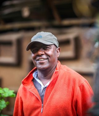 Artist Elias Sime in a cap and a red top