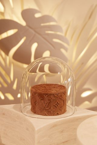 A cake under glass cloche with Louis Vuitton monogram