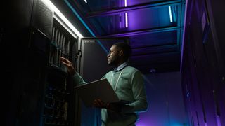 man checking on server units in data center