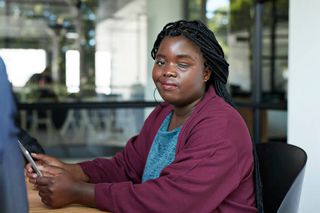 Portrait of young businesswoman with disability using digital tablet at workplace