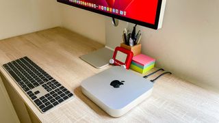 Apple Mac mini M2 sitting on a desk hooked up to an Apple Studio Display