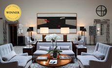 Hotel room with grey sofas, a wooden coffee table and modern décor 