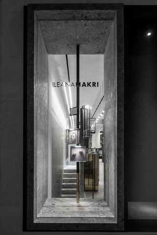 Shop interior of Greek Jewellery designer Ileana Makri with wooden floors, black cabinets, glass display cabinets and gold mirrors