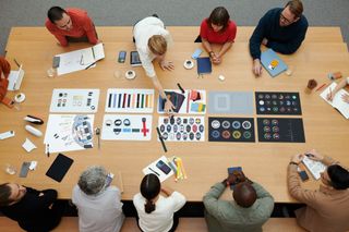 View from above of members of the Apple Design Team sitting at a meeting table in Apple Park to discuss the Apple Watch