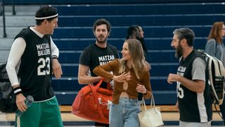 Four people stand on a basketball court