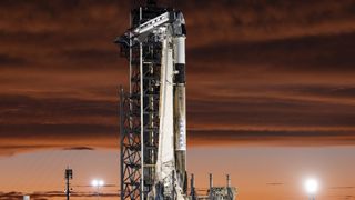 SpaceX's black and white Polaris Dawn Falcon 9 rocket stands on the launch pad in stunning twilight.