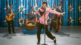 Austin Butler as Elvis, performing on stage with a band behind him, in ELVIS