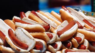 Hot dogs piled atop a platter await consumption at the Nathan&#039;s Hot Dog Eating Contest live stream