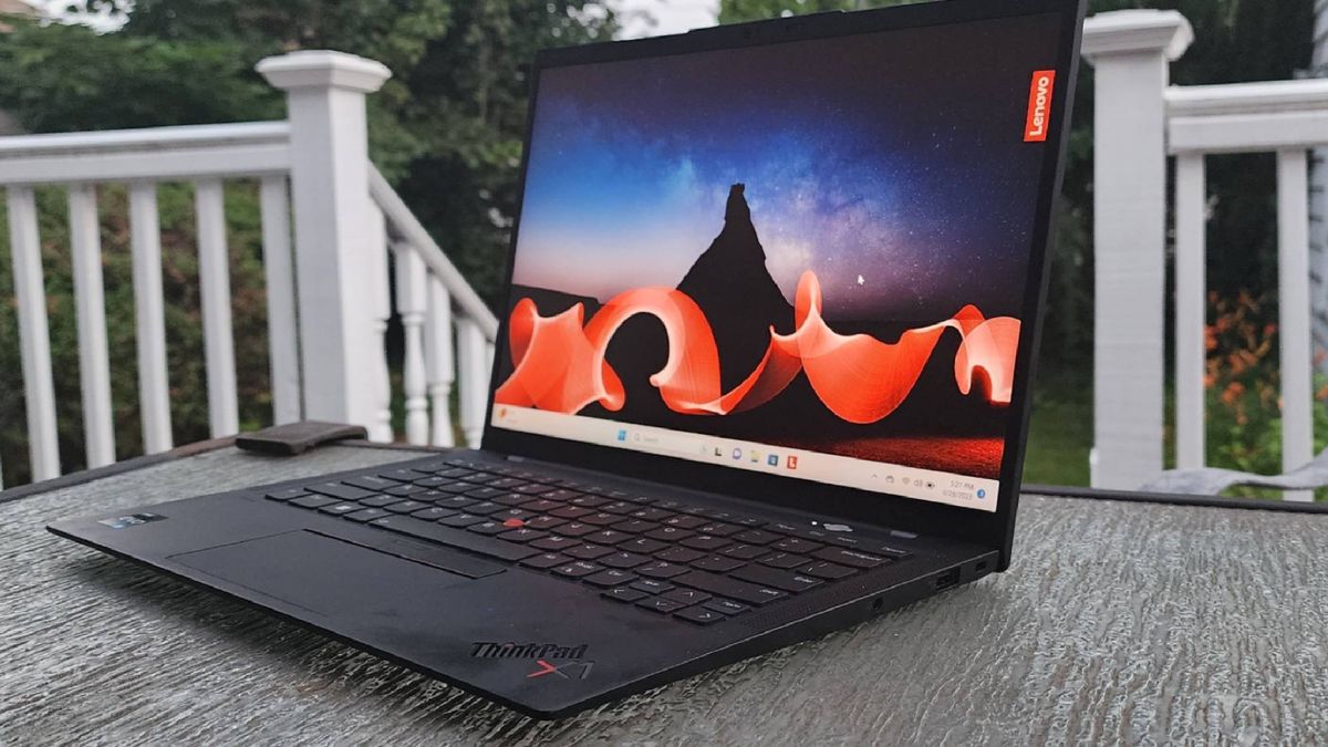 Lenovo ThinkPad X1 Carbon Gen 11 on a wooden table outside.