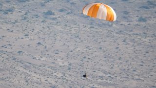 a sample space capsule parachuting to Earth in a test