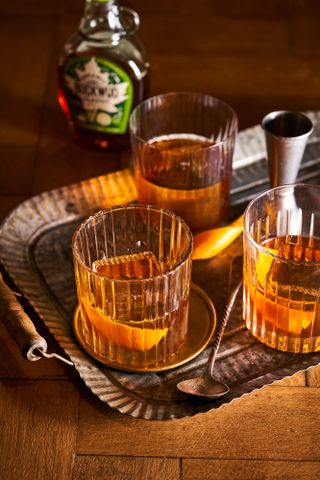 Maple Syrup Old Fashioned cocktail, on a tray with pourer and mixing spoon