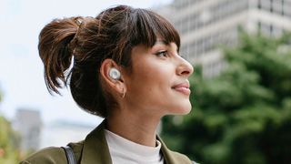 Woman wearing Samsung Galaxy Buds FE.