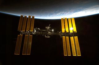 Sunlight glints off the International Space Station.