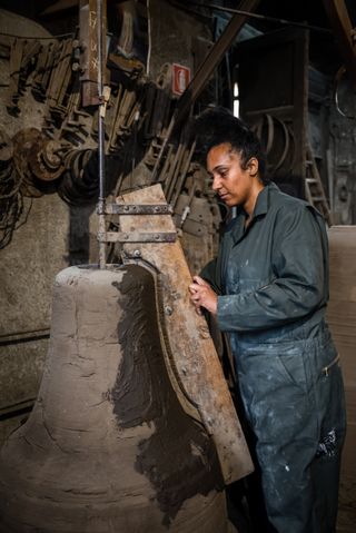 Dominique White at work with metal and old bell