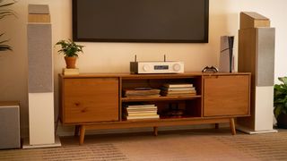 JBL MA510 on a wooden media unit flanked by two speakers and a TV above