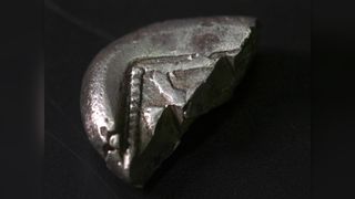 The coin dates from the sixth or fifth centuries B.C. It was deliberately broken in two, probably in the fourth century B.C. to use each half as the value of its weight in silver.