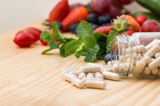 Bottle of supplements or vitamins on a wooden table.