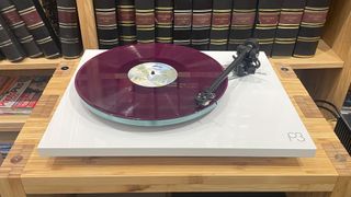 Rega Planar 3/Nd3 turntable package on wooden hi-fi rack playing purple vinyl record