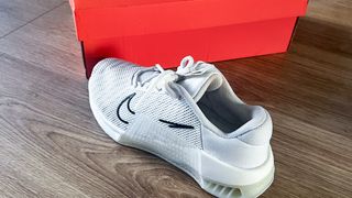 Nike Metcon 9 in white and black next to a shoe box