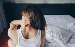 Woman stretches her neck after waking up