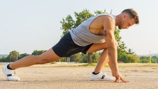 Man in runner's lunge during outdoor workout 