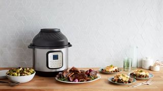 An instant pot next to a plate of food