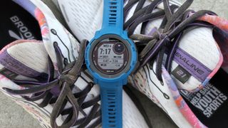 The Garmin Instinct 2 Solar sitting on a pair of shoes