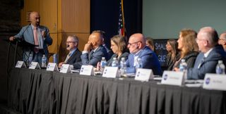 a group of people in suits at a table under a nasa logo