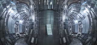 Bright lights illuminate the circular tunnel in the tokamak nuclear fusion reactor.