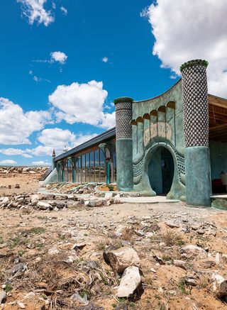 Earthship community in Taos showing colourful off grid homes nestled into the desert earth