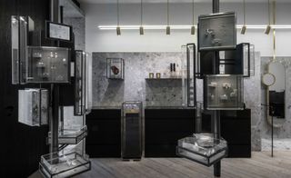 Shop interior of Greek Jewellery designer Ileana Makri with wooden floors, black cabinets, glass display cabinets and gold mirrors