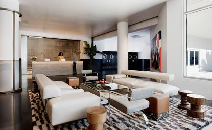 A polished white marble reception desk to greet visitors at NeueHouse's LA outpost