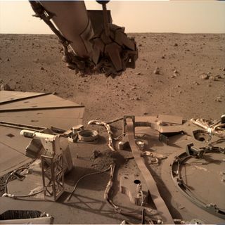 Dust has been building up on NASA's InSight Mars lander, as shown by this photo taken by the spacecraft’s Instrument Deployment Camera on Feb. 13, 2022.
