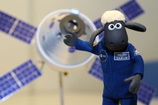 Shaun, the title character from the Aardman stop motion TV series "Shaun the Sheep," poses with a model of the Orion spacecraft and European service module.